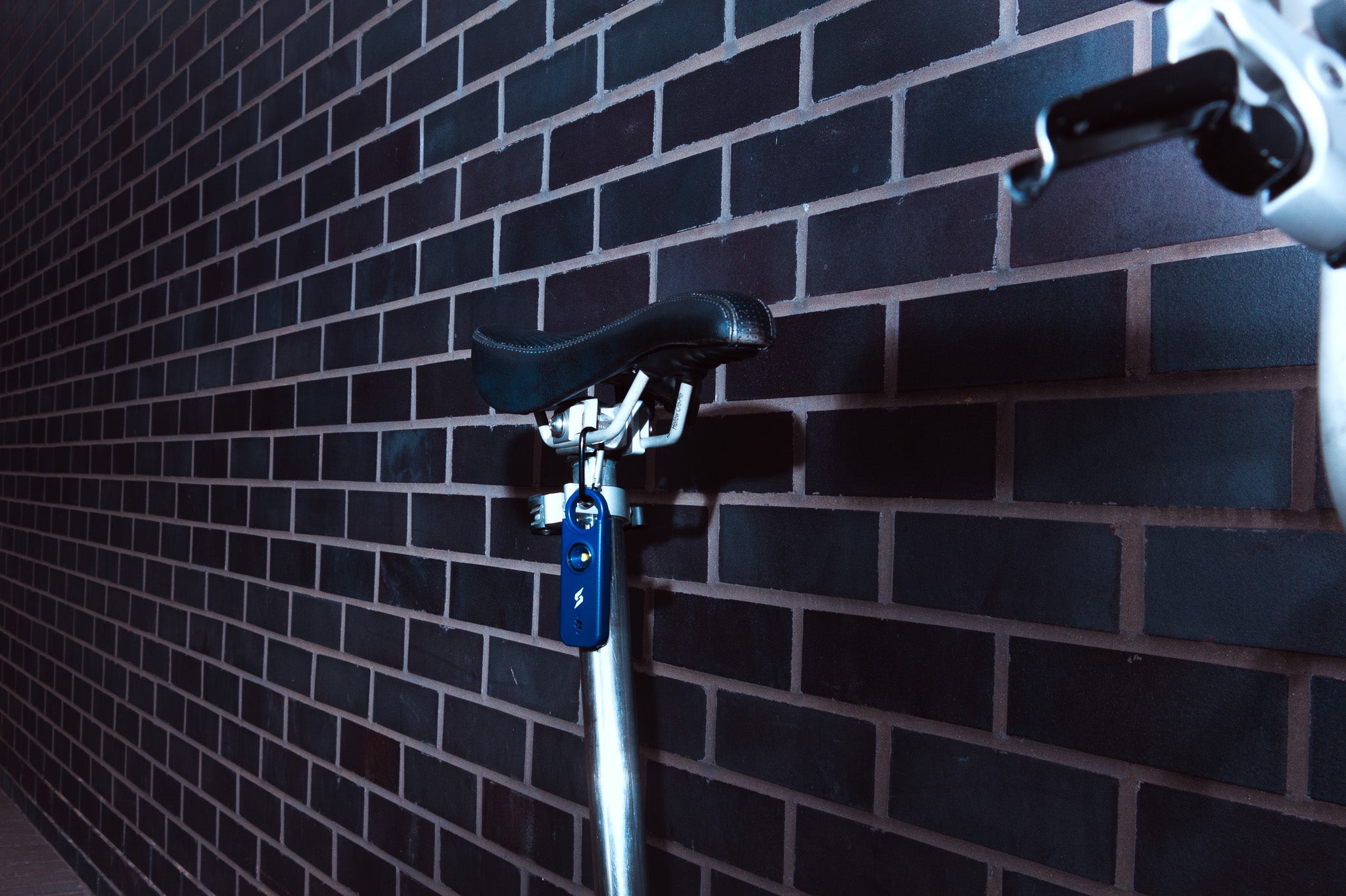 bike against a brick wall protected by a personal safety alarm with motion sensor