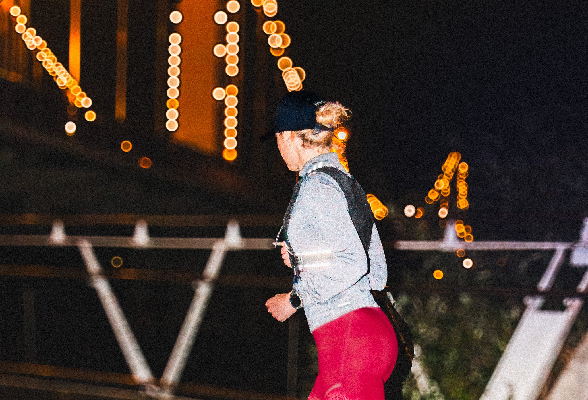 woman with vest and personal safety alarm running at night